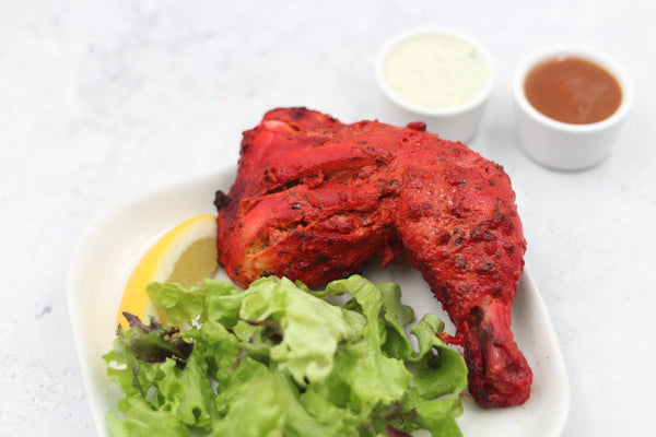 Tandoori chicken, marinated chicken pieces cooked until charred