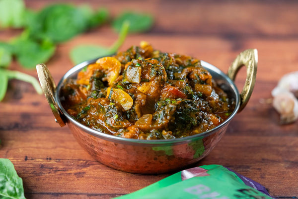 Chicken saag, a chicken and spinach curry made with Bhuna sauce, served in a balti dish