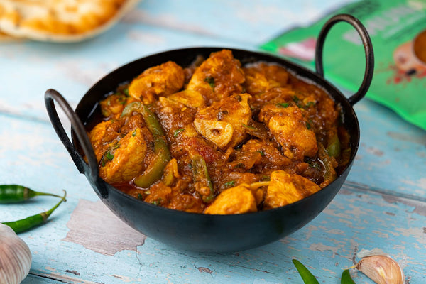 Garlic chilli chicken, a hot curry with sliced garlic, green chillies and peppers, served in a balti dish